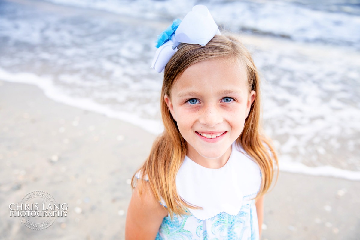 little girl on the beach  - sun dress - blue bow in hair - Bald Head Island Photographers - BHI Photography - Kids Portraits -  Pictures on Bald Head Island - BHI Photo Services - Chris Lang Photography 