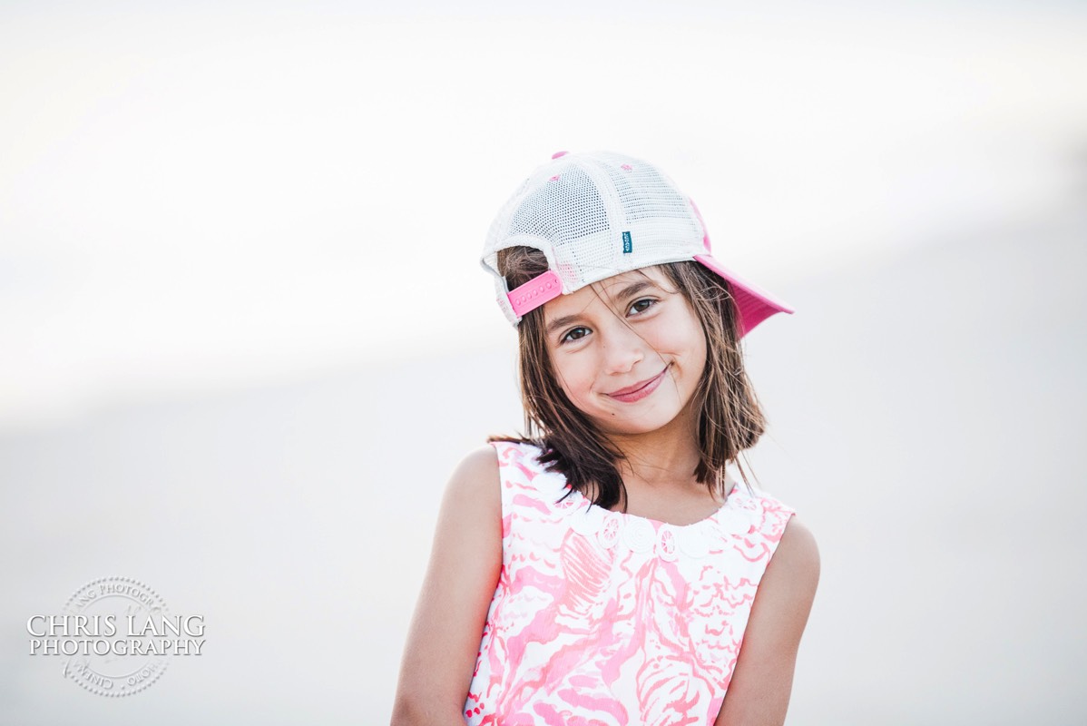 fun beach picture of little girl  in a pink hat - Places for family vacation - Bald Head Island Photographers - BHI Photography - Kids Portraits -  Pictures on Bald Head Island - BHI Photo Services - Chris Lang Photography  