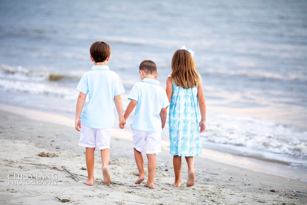 young kids holding hands - walking down the beach - Places for family vacation - Bald Head Island Photographers - BHI Photography - Kids Portraits -  Pictures on Bald Head Island - BHI Photo Services - Chris Lang Photography 