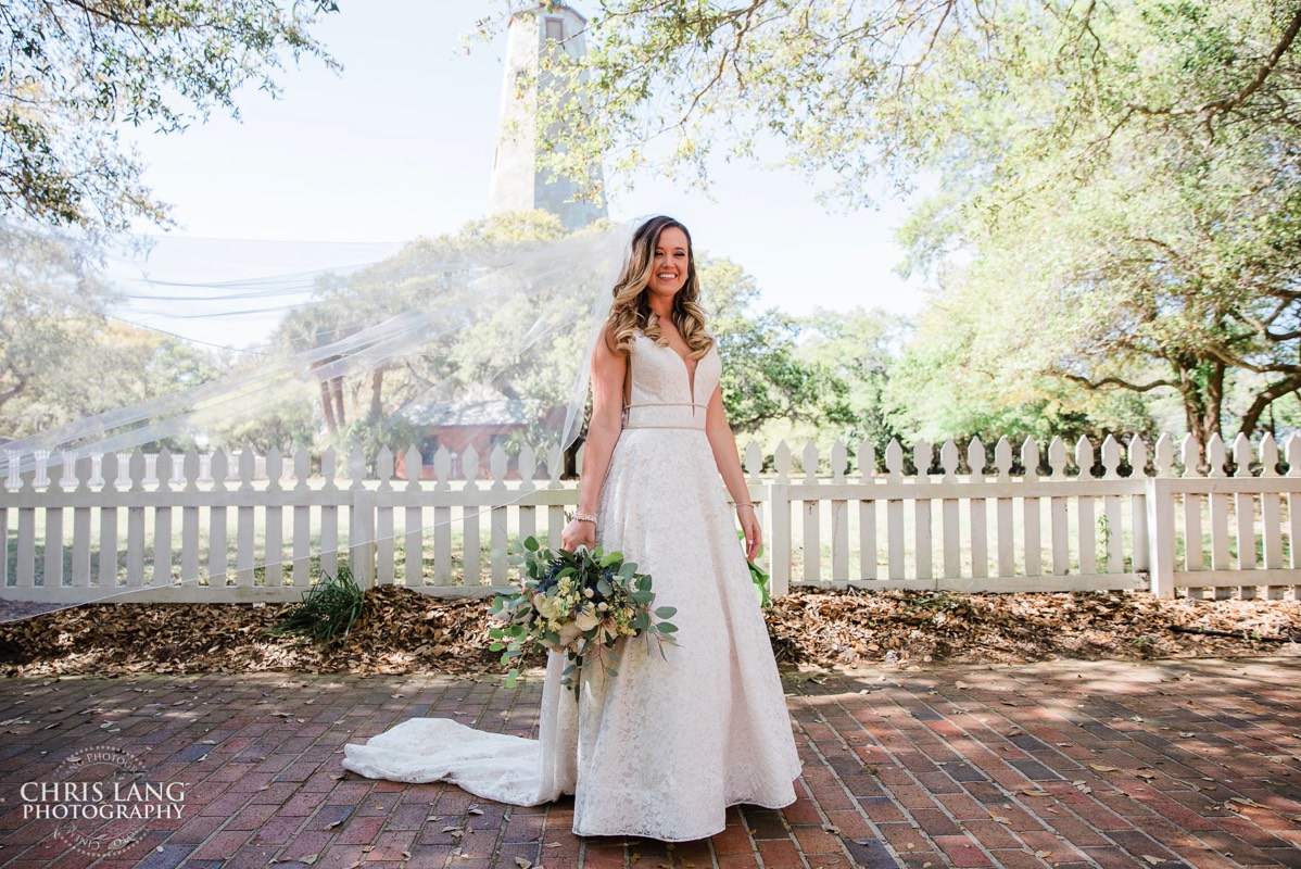 pretty bride in front of Old Baldy Lighthouse  - Bald Head Island NC Wedding Photography - BHI Wedding Photographers - Wedding Dress -  Chris Lang Photography - Destination Weddings -  Bald Head Island wedding picture - BHI Weddings