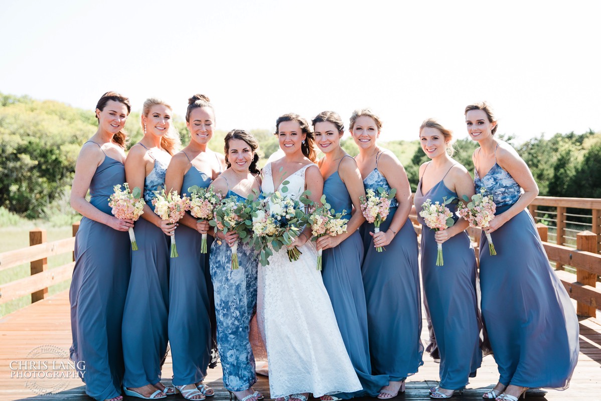 Bridsmaids with bride on the wood bridge in fron of old baldy lighthouse  - Bald Head Island NC Wedding Photography - BHI Wedding Photographers - Wedding Dress -  Chris Lang Photography - Destination Weddings -  Bald Head Island wedding picture - BHI Weddings