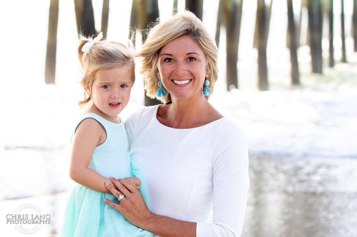 Mom holding daughter on the beach posing for picture -Topsail Island Photography - Topsail Island NC Photographers - Chris Lang Photography -  Beach Photography - Family Photographer - Family photo - Beach Photographer - Beach Portraits -  Coastal Lifestyle Photography