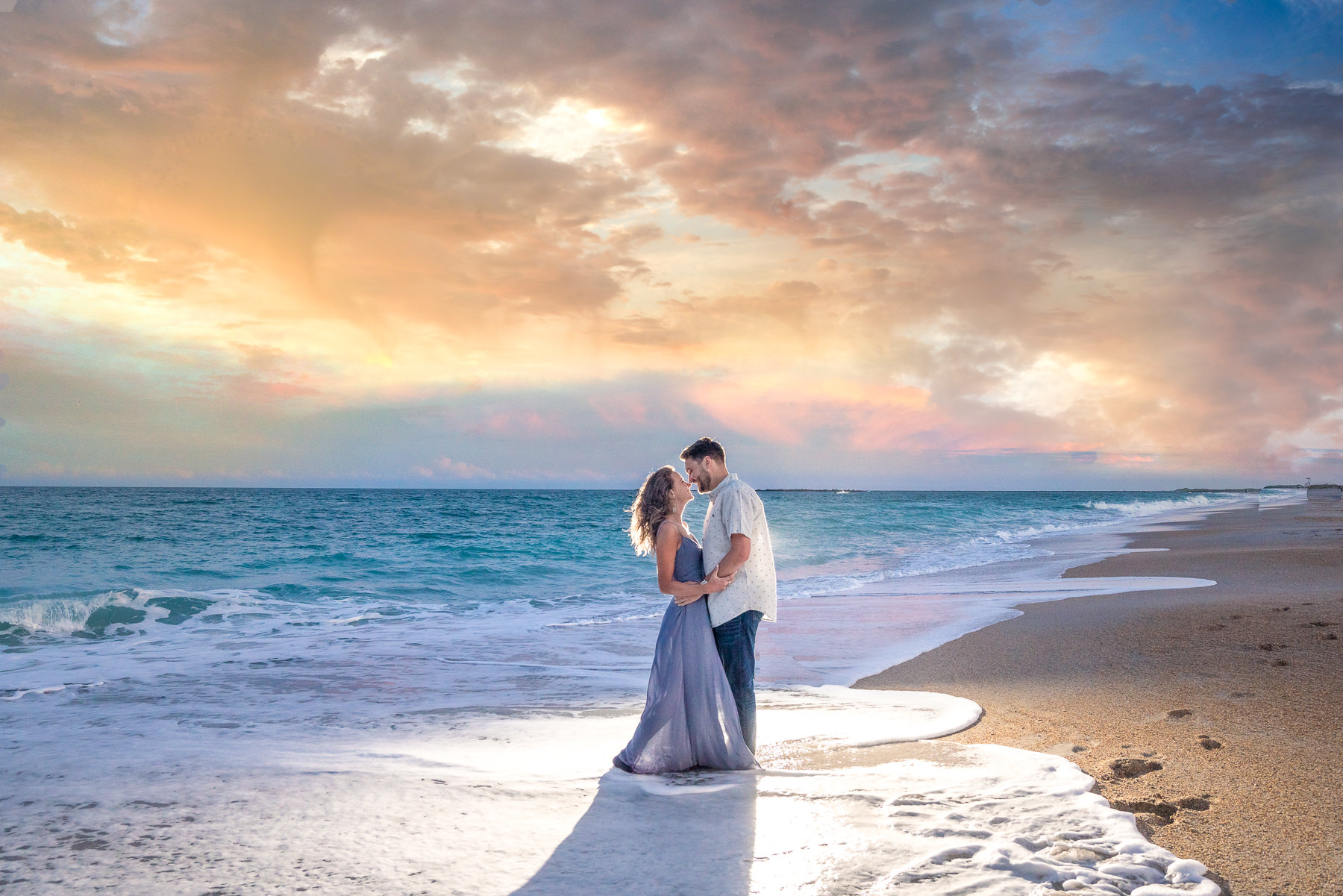 Sunset Photo on Wrighsville beach - Engaged Couple Standing in the ocean waves - Wrightsville Beach Engagement Photography - Wrightsville Beach Photographers - Engagement Photographer -  Chris Lang Photography - Lifestyle Engagement Photo