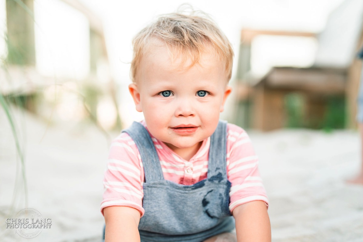 imae of young boy sitting on the beach - blue eyes - Wrightsville Beach Family Photography - Wrightsville Beach Photographers - Beach Family Photos- Chris Lang Photography  
