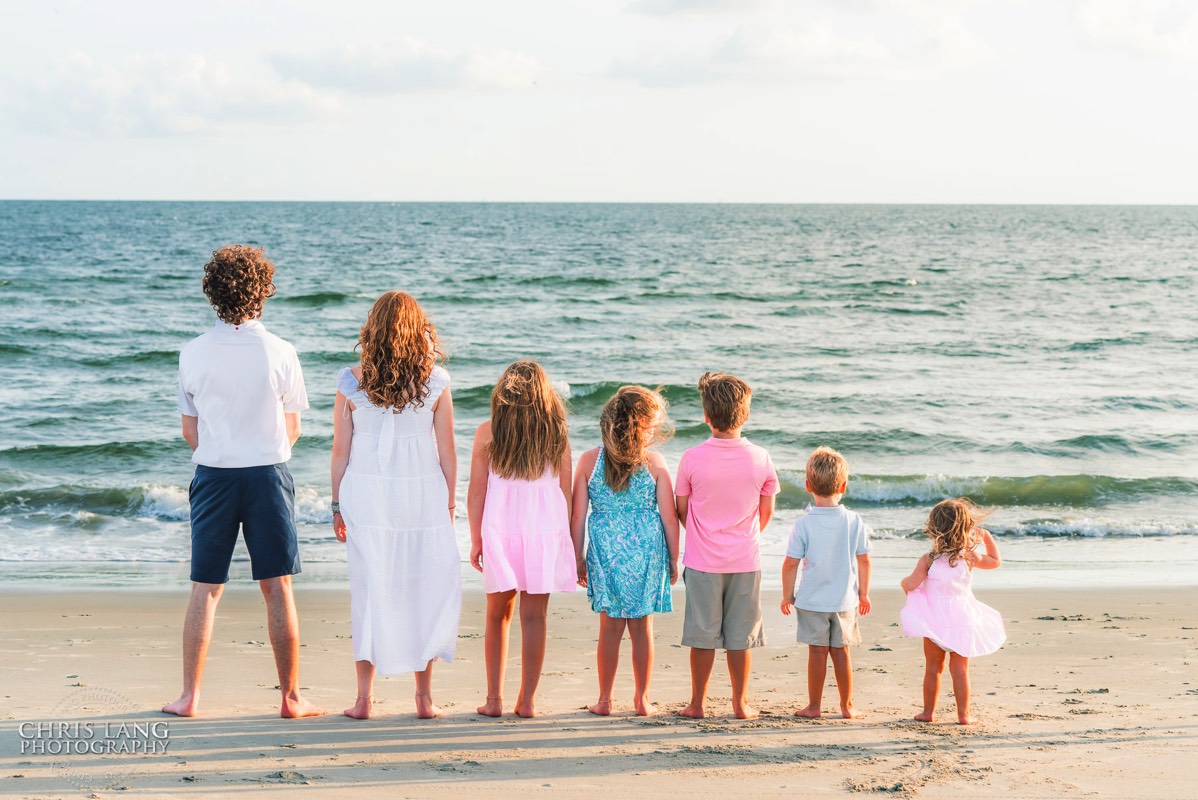 image of a group of kids looking at the waves - family photo ideas - Wrightsville Beach Family Photography - Wrightsville Beach Photographers - Beach Family Photos- Chris Lang Photography  