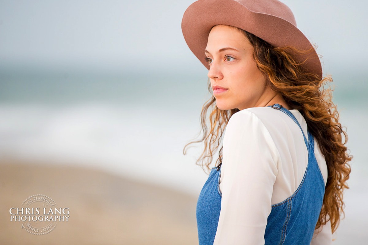 Image of highschool senior girlon the beach wearing a hat while posing for photo - outfit ideas for seniors -  Wrightsville Beach High School Senior Photography - Wrightsville Beach Photographers - Beach Senior Portrait  Photos- Chris Lang Photography  