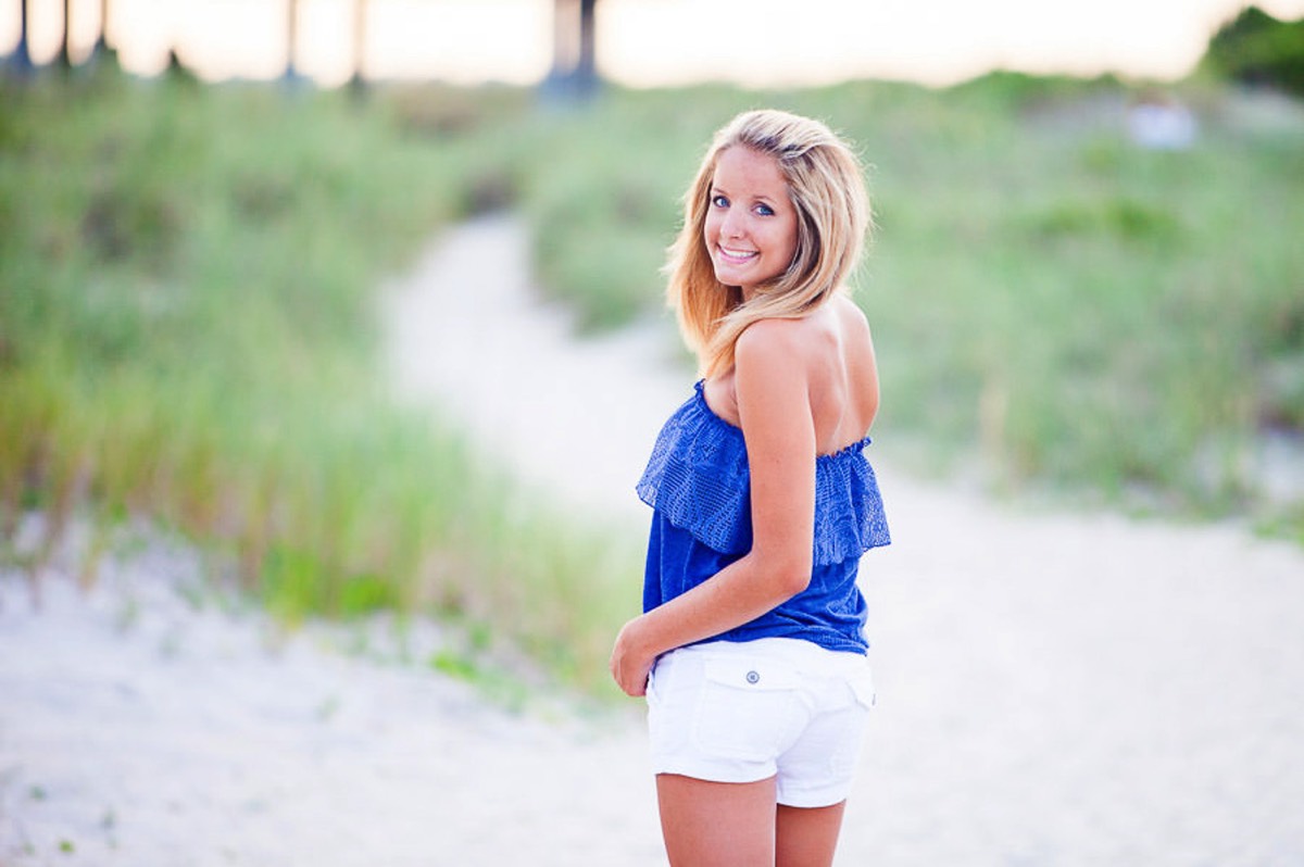 photo of highschool senior girl posing for senior picture on the beach  having fun  - white shorts and blue shirt - Wrightsville Beach High School Senior Photography - Wrightsville Beach Photographers - Beach Senior Portrait  Photos- Chris Lang Photography  