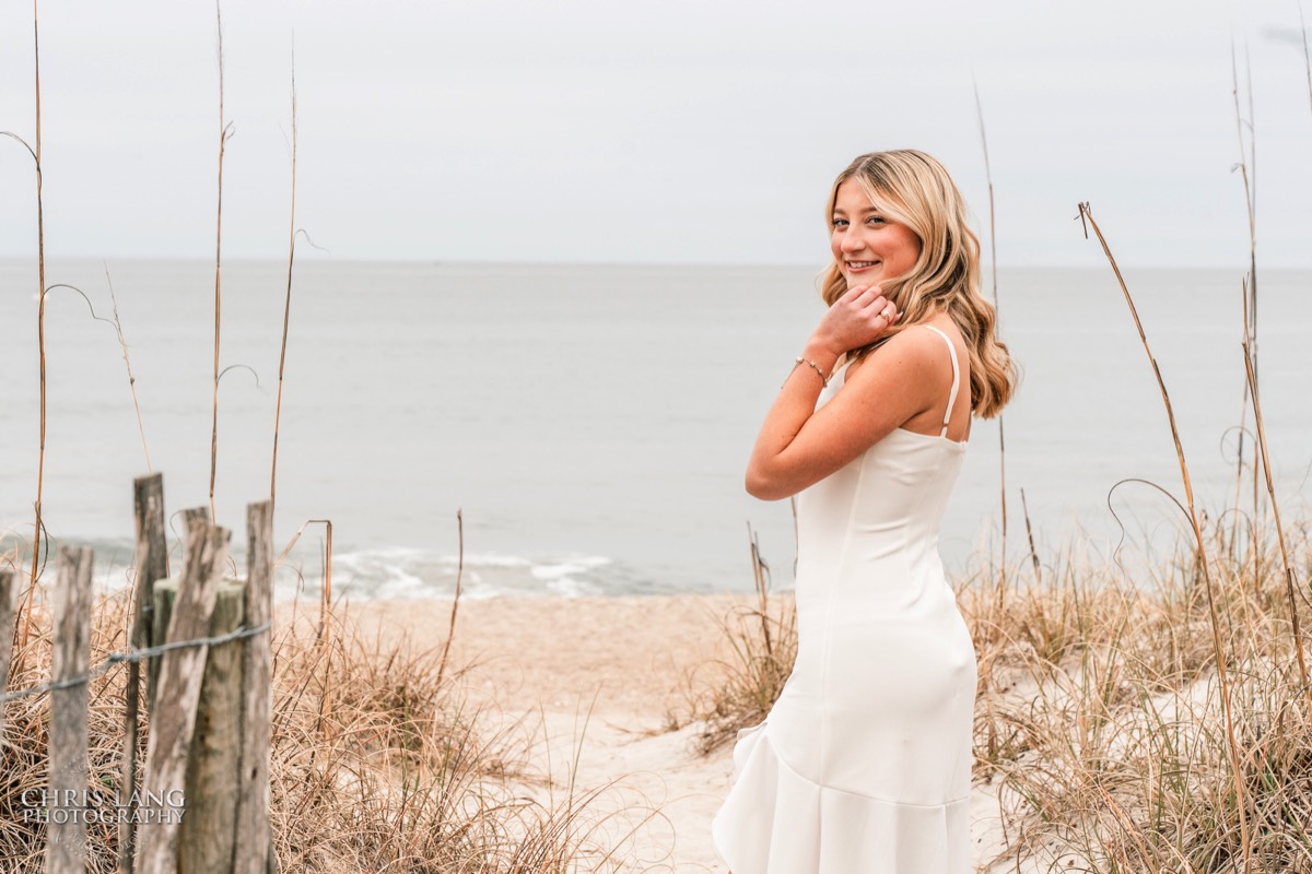image of highschool senior girl on the beach  wearing a white dress  - location tat the oceaninc -Wrightsville Beach High School Senior Photography - Wrightsville Beach Photographers - Beach Senior Portrait  Photos- Chris Lang Photography  