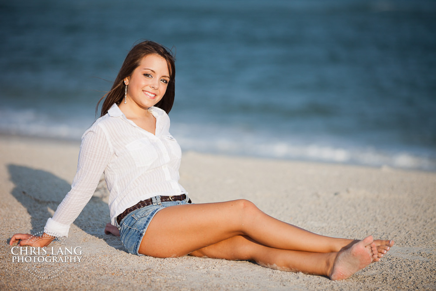 Phot of iHigh School Senior sitting on the beach - Wrightsville Beach - Senior Photo Session - Senior Portriat Photographer- Senior Portraits - Senior Portrait photo ideas - Chris Lang Photography 