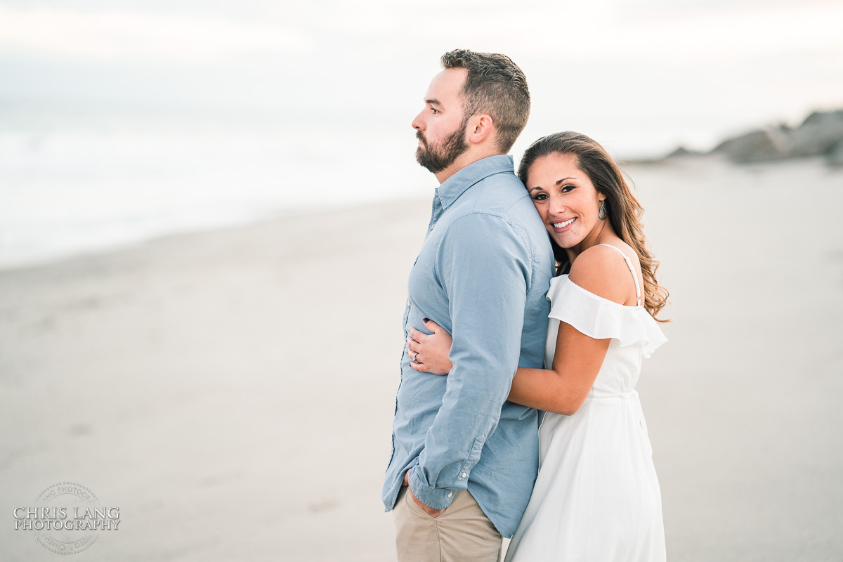 Bright and Airy Engagement photo - Couple wrapped  in Christmas lights on the beach - Fort Fisher North Carolina -  Engagement Photography - Wedding Ideas - Popular engagement photography locations - Lifestyle engagement photo -  Ft Fisher engagement photographers - Engagement session ideas - New trends in engagement photography - Chris Lang Photography - Engagement photos 