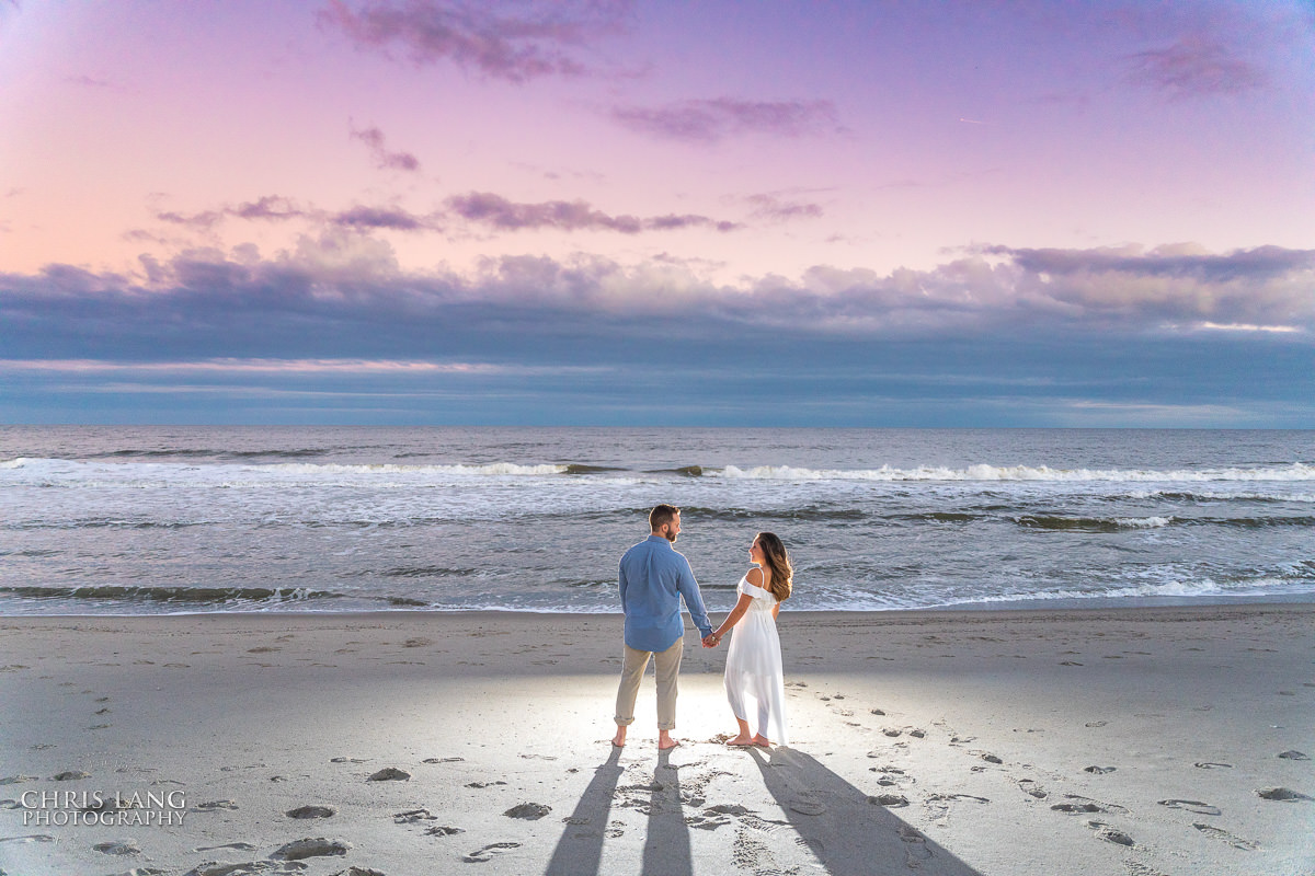 Sunset - Couple - romance - holding hands - Fort Fisher North Carolina -  Engagement Photography - Popular engagement photography locations - Lifestyle engagement photography -  Ft Fisher engagement photographers - Engagement session ideas - Trends in engagement photography - Chris Lang Photography - Engagement photos 