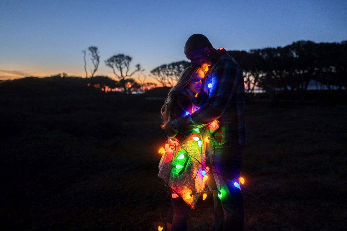 Couple wrapped  in Christmas lights  - Fort Fisher North Carolina -  Engagement Photography - Wedding Ideas - Popular engagement photography locations - Lifestyle engagement photo -  Ft Fisher engagement photographers - Engagement session ideas - New trends in engagement photography - Chris Lang Photography - Engagement photos 
