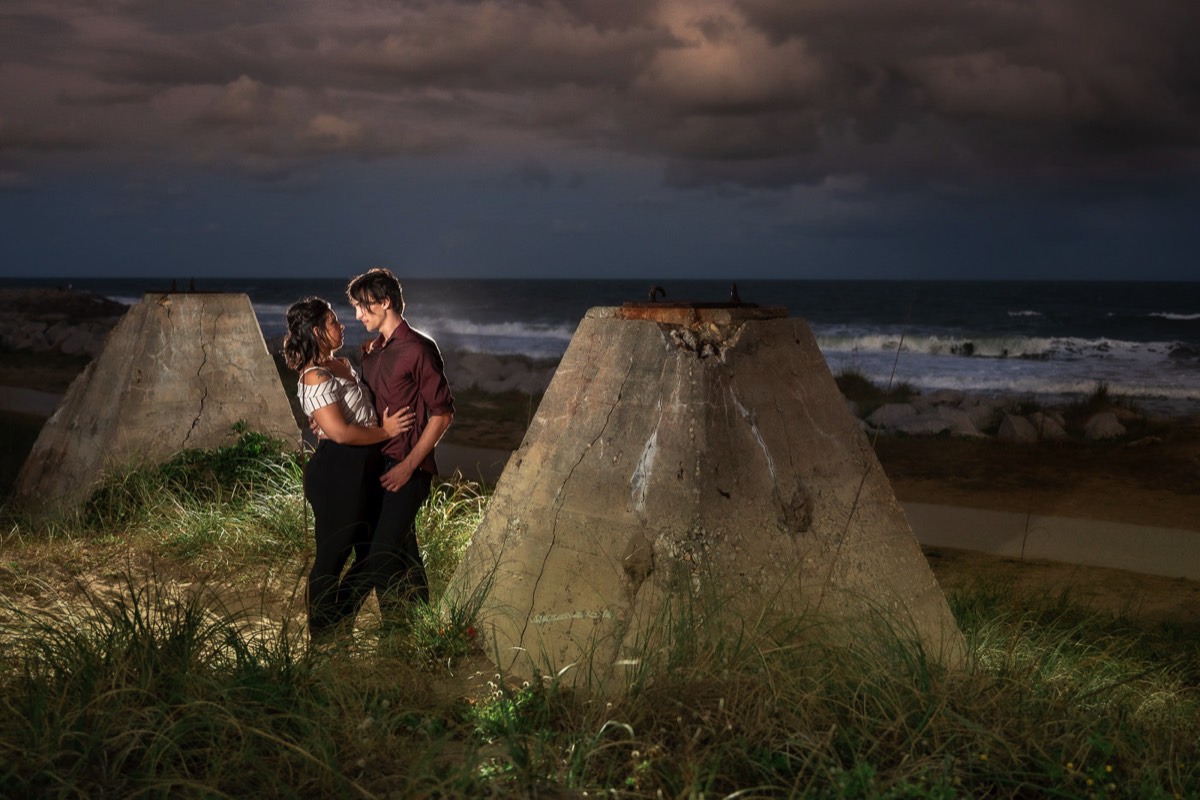 Dark and moody style twilight enagement photo - Couple wrapped  in Christmas lights on the beach - Fort Fisher North Carolina -  Engagement Photography - Wedding Ideas - Popular engagement photography locations - Lifestyle engagement photo -  Ft Fisher engagement photographers - Engagement session ideas - New trends in engagement photography - Chris Lang Photography - Engagement photos 