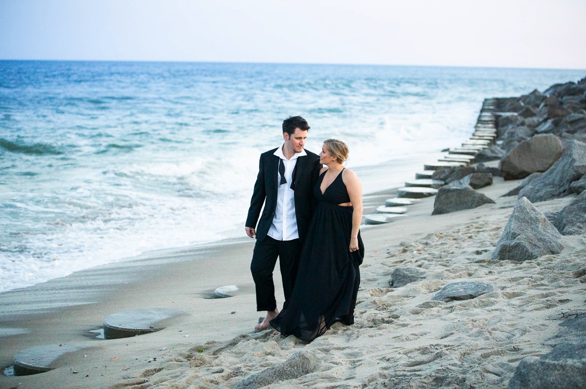 A walk on the beach - Dark & Moody Style  Engagement photo - Couple wrapped  in Christmas lights on the beach - Fort Fisher North Carolina -  Engagement Photography - Wedding Ideas - Popular engagement photography locations - Lifestyle engagement photo -  Ft Fisher engagement photographers - Engagement session ideas - New trends in engagement photography - Chris Lang Photography - Engagement photos 
