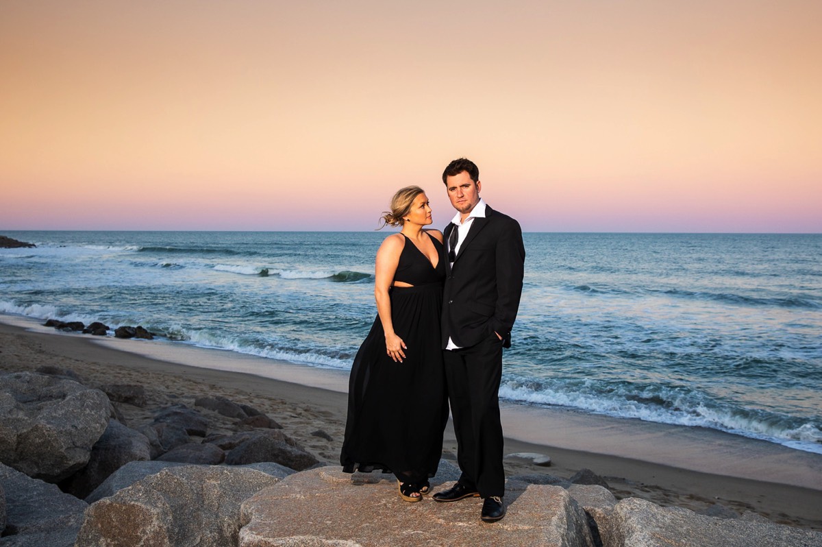couple sunset photo - Dark & Moody Style  Engagement photo - Couple wrapped  in Christmas lights on the beach - Fort Fisher North Carolina -  Engagement Photography - Wedding Ideas - Popular engagement photography locations - Lifestyle engagement photo -  Ft Fisher engagement photographers - Engagement session ideas - New trends in engagement photography - Chris Lang Photography - Engagement photos 