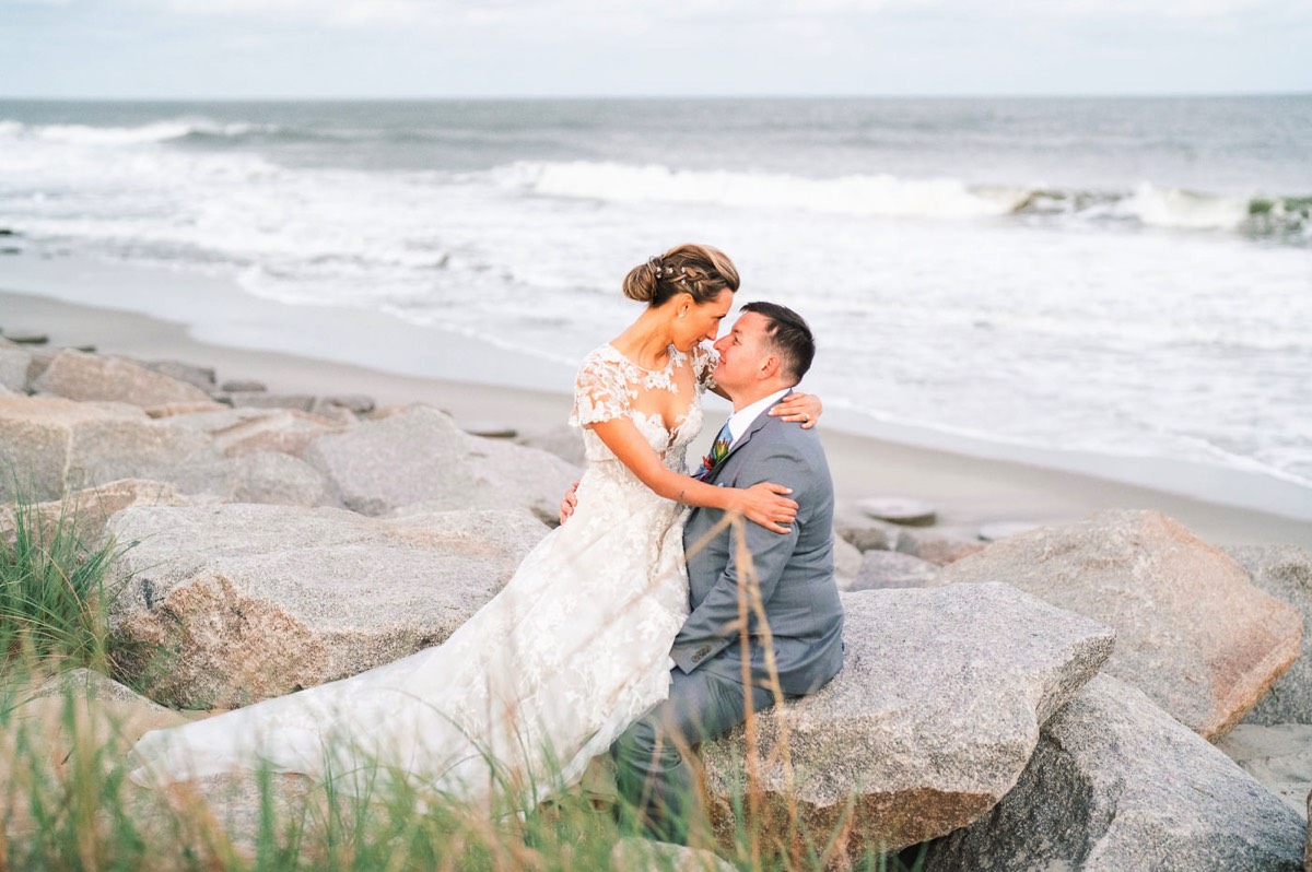 Bride & groom on the beach rocks at   Fort Fisher North Carolina -  Wedding Photography - Wedding Ideas - Bride - Groom - Wedding Dress - Chris Lang Photography- Popular wedding location - 