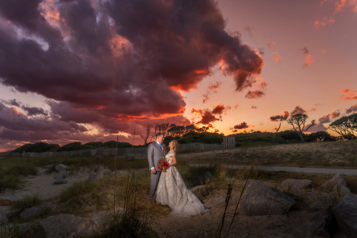 Sunset wedding photo of bride & groom at   Fort Fisher North Carolina -  Wedding Photography - Wedding Ideas - Bride - Groom - Wedding Dress - Chris Lang Photography- Popular wedding location - 