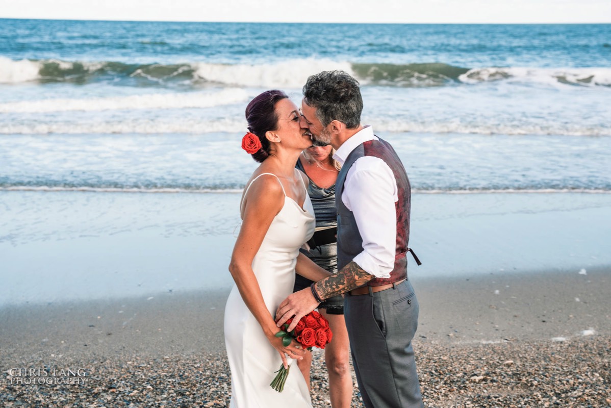 Bride and groom first kiss - beach wedding at   Fort Fisher North Carolina -  Wedding Photography - Wedding Ideas - Bride - Groom - Wedding Dress - Chris Lang Photography- Popular wedding location - 