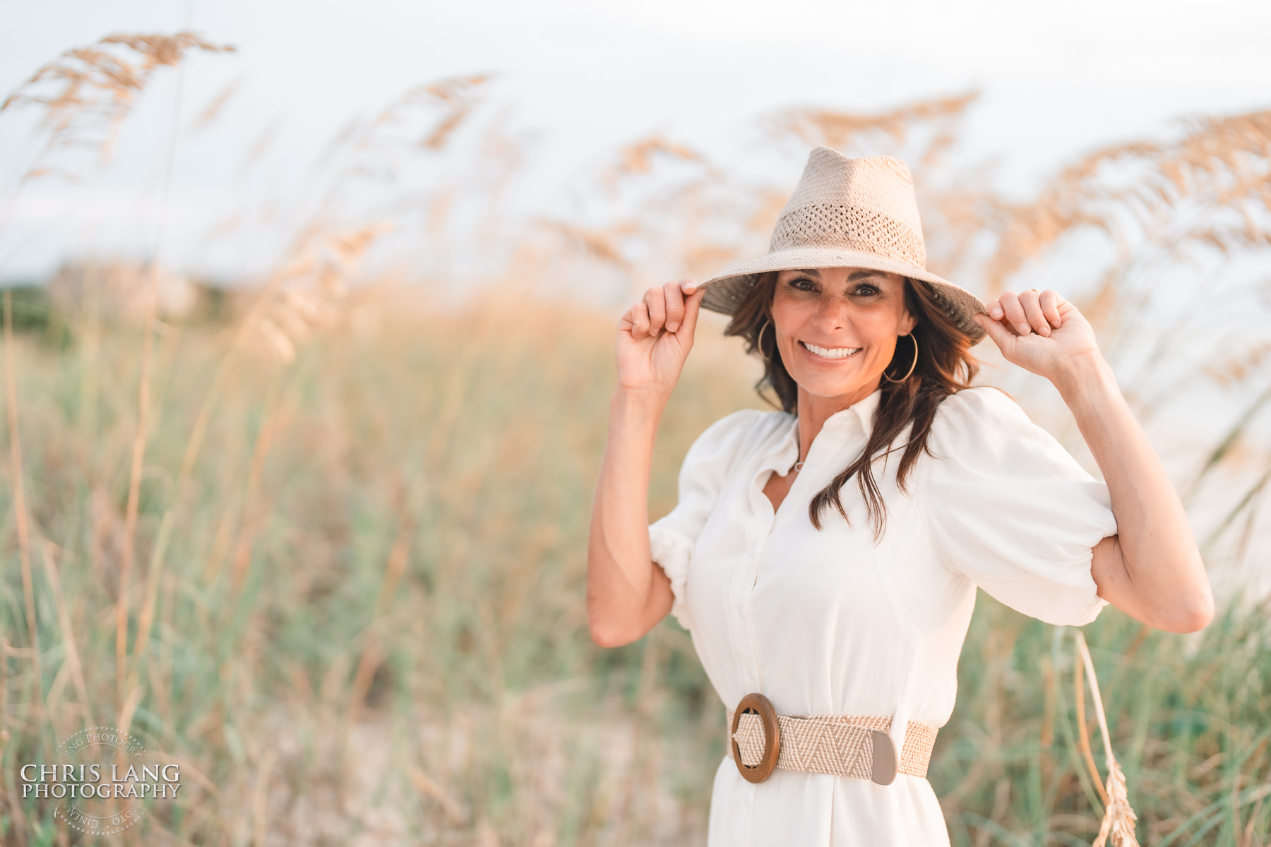 lifestyle headshot of female wearing a hat on the beach - Bald head Island - - Wilmington NC Headshot Photography - Lifestyle Headshot - Branding Headshots  -Chris Lang Photography -  