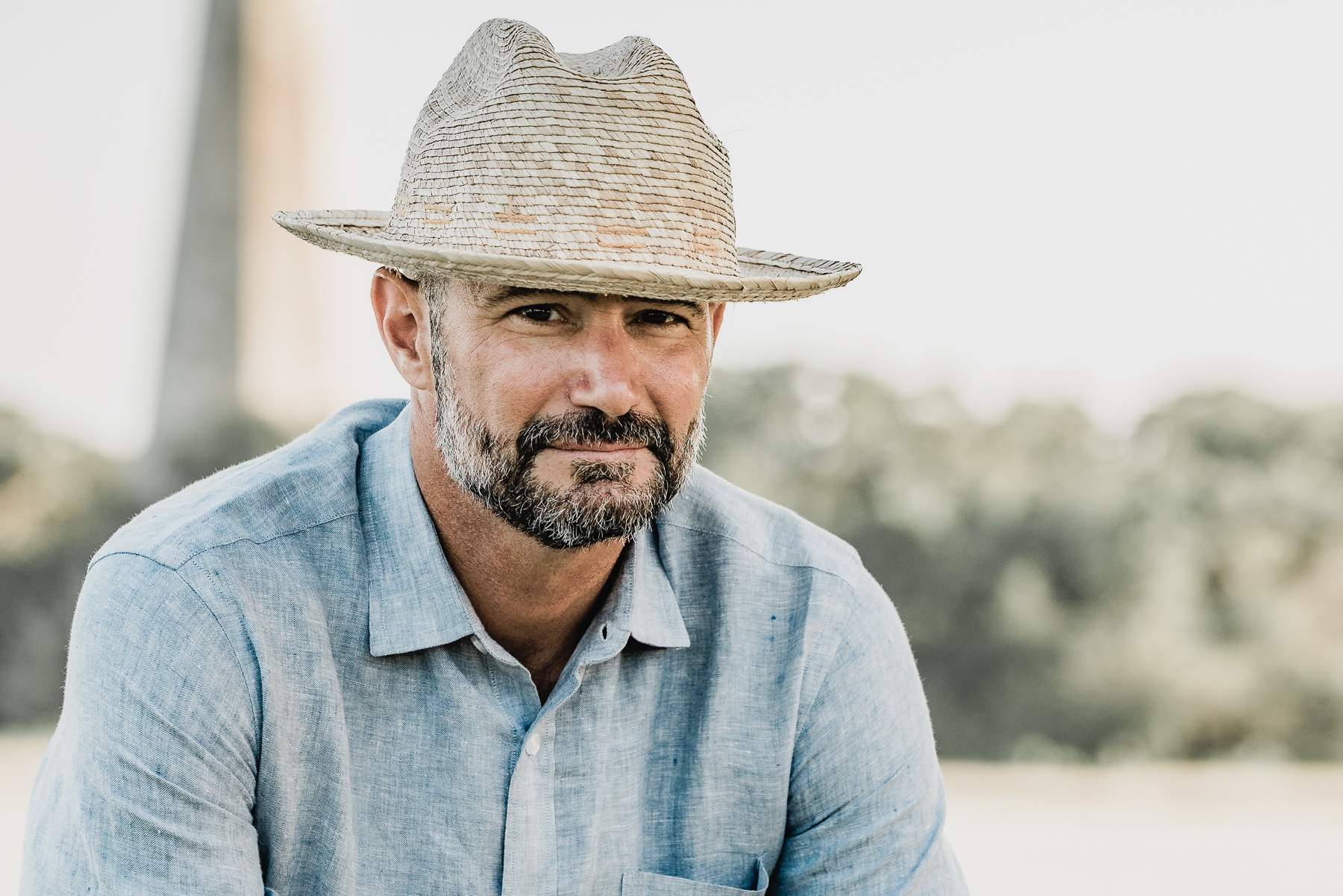 Lifestsyle headshot of a male wearing a straw had and linen shirt -  Island Life - Bald Head Island  Photographers - - Wilmington NC Headshot Photography - Lifestyle Headshot - Branding Headshots  -Chris Lang Photography -  