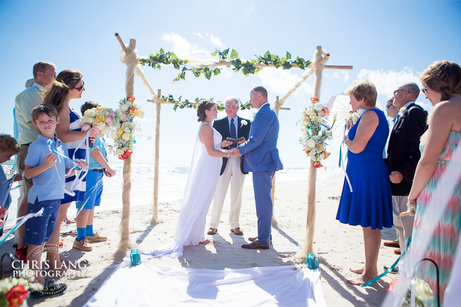 Bride and groom at alter during a beach wedding on Topsail Island NC - NC Wedding Photographers